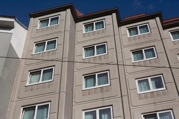 facade of modernist european apartment building against blue sky