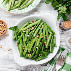 Sauteed green beans with pine nuts in a baking dish, healthy side dish.