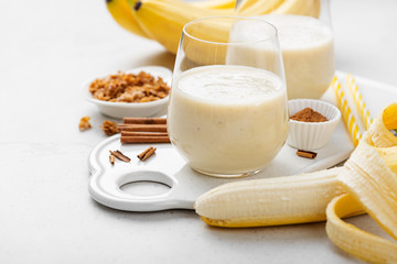 Banana smoothie in glass with granola and cinnamon for healthy breakfast.