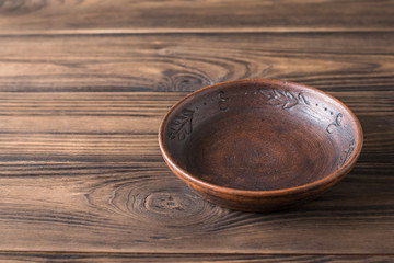 Clay bowl on a brown wooden table.