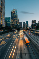 Fototapeta premium Long exposure of traffic on the 110 Freeway and the skyline in downtown Los Angeles, California
