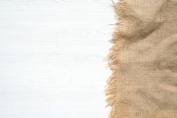 Sackcloth on a white kitchen wooden table background with copy space.
