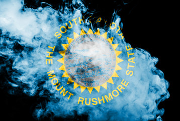The national flag of the US state South Dakota in against a gray smoke on the day of independence...