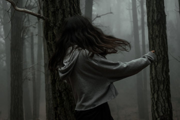 Fototapeta na wymiar Young woman in the dark forest