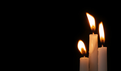 Burning candles in darkness with space for text. Funeral and memorial concept and symbol.