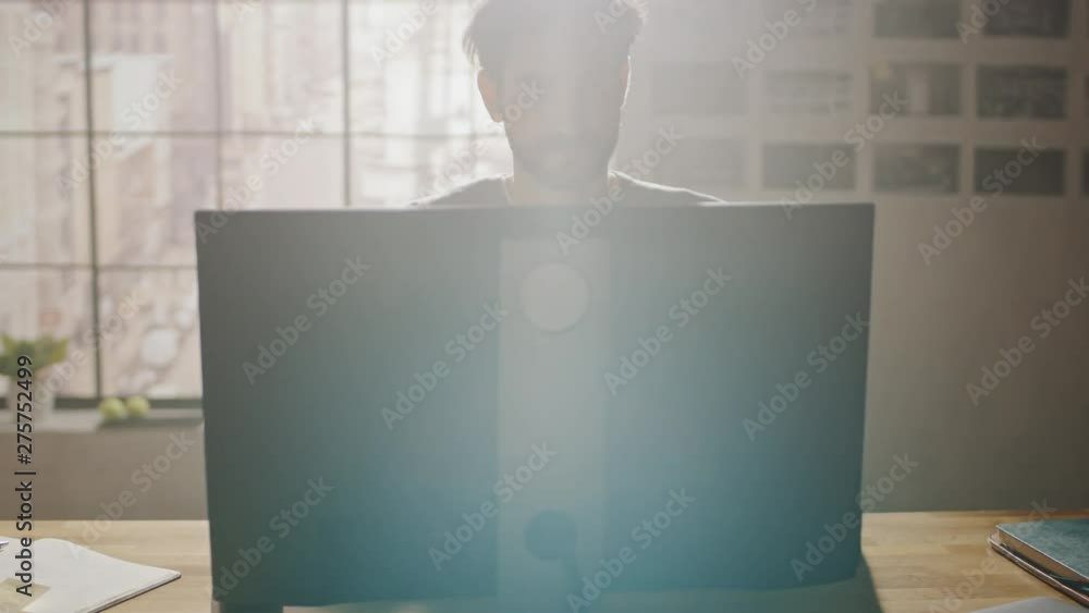 Poster Creative Designer Sitting at His Desk in Office Studio Working on a Desktop Computer with Smartphone Software Development Application on Screen. Web, App Developer. 360 Degree Tracking Arc Shot