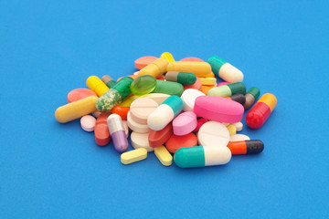 Medication and healthcare concept. Colorful tablets and pills on blue background