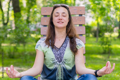 Young Woman Doing Yoga In The Park On The Bench Portrait Of