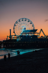 The Santa Monica pier at sunset, in Los Angeles, California - obrazy, fototapety, plakaty