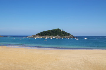 Fototapeta na wymiar Clear Santa Island in La Concha Bay, San Sebastian, Basco Country, Spain