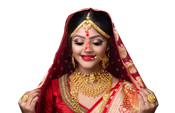 Indian Or Bengali Bride With Sindur Or Sindoor In Forehead Wearing Red Sari And Gold Jewelry , Studio Shot On White Background.