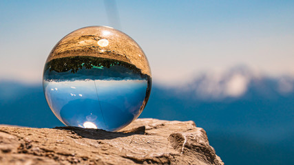 Fototapeta na wymiar Crystal ball alpine landscape shot on a rock at the Herzogstand summit, Walchensee, Bavaria, Germany