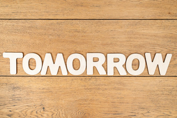 Word tomorrow on a wooden board