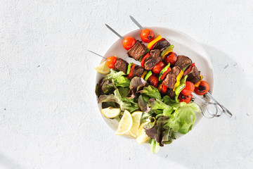 Plate with beef grilled meat kebab on a white table top view