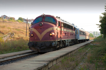 Naklejka premium Kosovo - Pristina - Kosovo railways (Trainkos) diesel locomotive is going to depart with international passanger train on the route Pristina, Kosovo - Scopje, Macedonia (with blured backgorund)