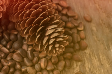 inshell pine nuts and cones on a wooden background. Place for your text. Toning