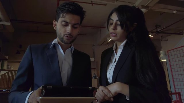 Smart intelligent good-looking business team in corporate formals working together to find solution with discussion, ideation and implementation on a touch screen smart tablet. 4k 60fps stabilized 