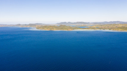 Fototapeta na wymiar Seascape with islands. Blue sea and large islands. Big island with woodland. Philippines, El Nido