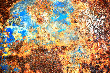 Multi colored background, rusty metal surface with blue point texture flaking and cracking.