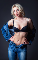 Studio fashion shot: beautiful sexy young woman in jeans and lingerie