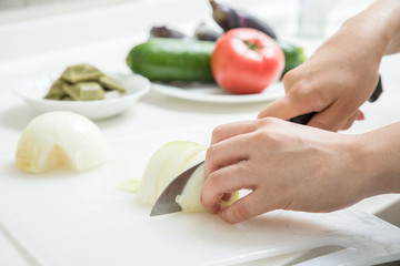 Obraz na płótnie Canvas 料理中の玉ねぎを切っている夏野菜背景野菜ぼかし