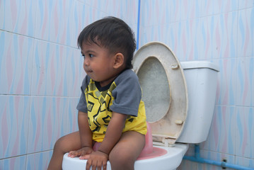 Cute little asian boy sitting on the toilet,Baby constipation Concept