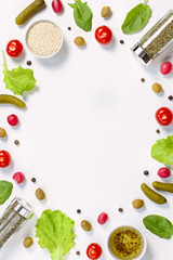 Salad ingredients layout on white desk. Food pattern with cherry tomatoes, cucumbers, greens, pepper and spices