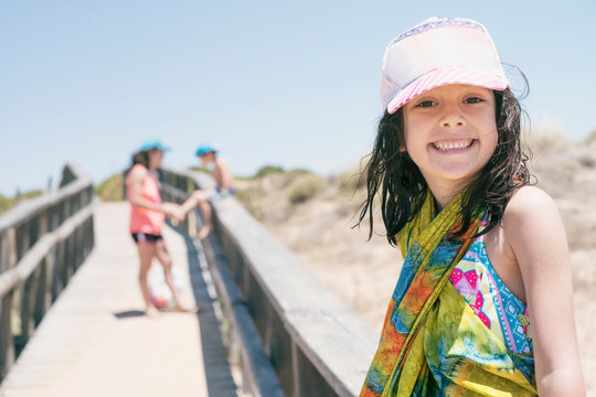 ni&ntilde;a de 6 a&ntilde;os tras un d&iacute;a de playa sonr&iacute;e y mira a c&aacute;mara