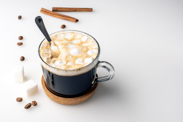 Cup of coffee, suger cubes, coffee beans, marshmallows and cinnamon sticks