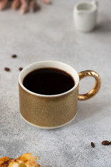 coffe with chocolate croissant on grey background