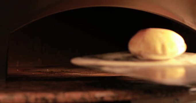 Take one ready pita bread from hot oven in restaurant