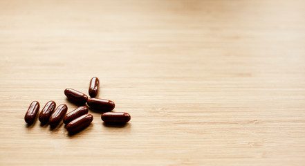 Herb capsule multivitamins on wooden plate for good brain , heart and health eating benefit