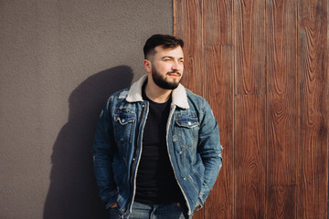 Handsome young man posing next to the wall