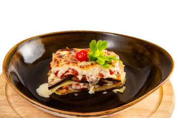 Delicious lasagne bolognese with mushrooms parmesan cheese in a brown cup isolated on white background