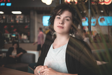 brunette with curly hair and short hair smiles. the woman in the office