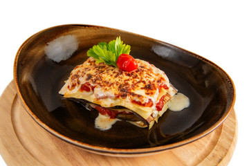 Delicious lasagne bolognese with mushrooms parmesan cheese in a brown cup isolated on white background