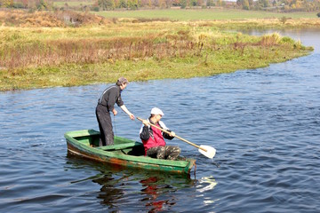 Two fishermen floating in a boat on the river