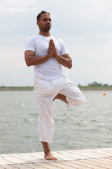 Young man doing yoga in morning park.man relax in nature