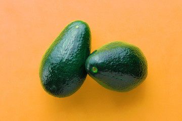 Ripe green avocado on orange background