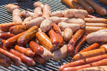 sausages and wieners are grilled on coals on the grill. Street food. fast food