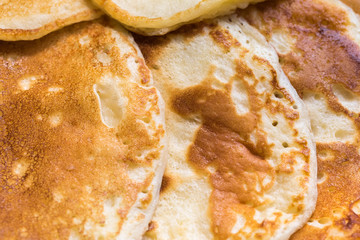 Close up. Newly-baked fritters and pancakes are laid out on a plate