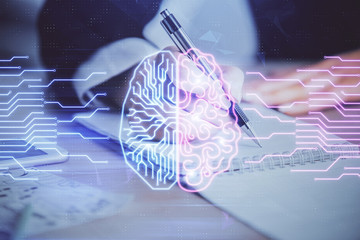 Double exposure of woman's writing hand on background with brain hud. Concept of learning.