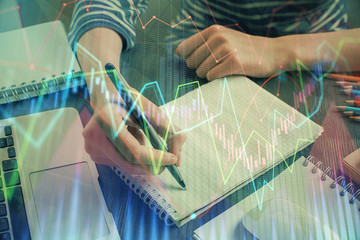 Fototapeta na wymiar Financial chart drawn over hands taking notes background. Concept of research. Double exposure