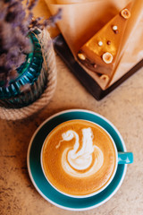 Coffee cappuccino and cake on the plate. Lavender on light table. Vertical background.