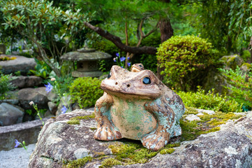 和風の庭園に置かれたカエルの置物