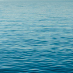 background of calm blue water with small waves and endless ripples