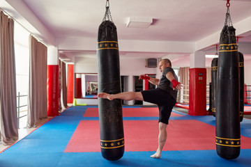 Fighter kicking the heavy bag