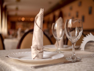 Table setting in a restaurant. Glasses, plates, appliances on the table.
