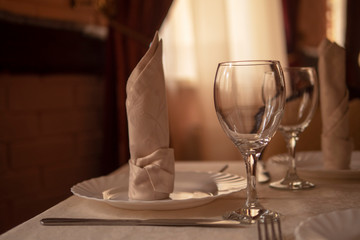 Table setting in a restaurant. Glasses, plates, appliances on the table.