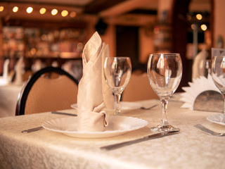 Table setting in a restaurant. Glasses, plates, appliances on the table.